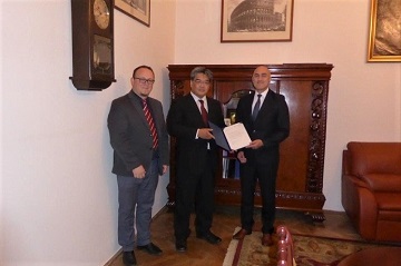 Professor Mizuhata (center) presents the formal letter from President Takeda to Vice-Rector Prof. Edigarian (right) (left: Professor Macyk)